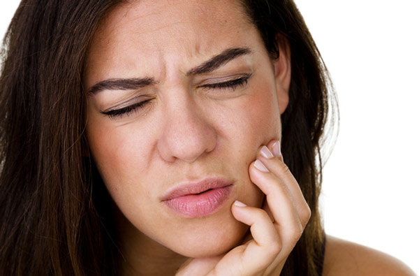 Woman holding jaw due to TMJ pain at Cramer Dental in Blue Bell, PA