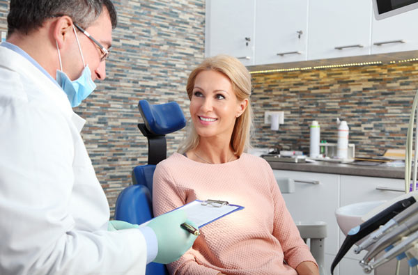 Woman talking to dentist during dental exam at Cramer Dental in Blue Bell, PA